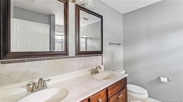 116 Argyll Ave, Aberdeen, NC 28315 - bathroom featuring toilet, a textured ceiling, double vanity, and baseboards