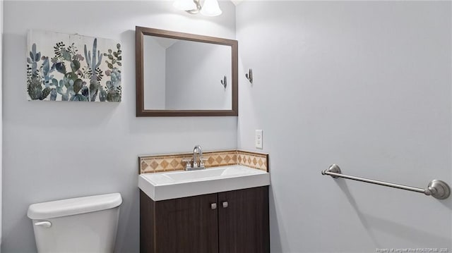 116 Argyll Ave, Aberdeen, NC 28315 - bathroom with toilet, vanity, and decorative backsplash