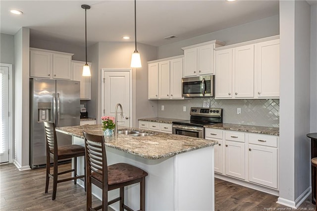 kitchen featuring appliances with stainless steel finishes, a sink, dark wood-type flooring, white cabinetry, and recessed lighting