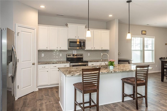 kitchen featuring appliances with stainless steel finishes, dark wood-style floors, decorative backsplash, white cabinetry, and recessed lighting