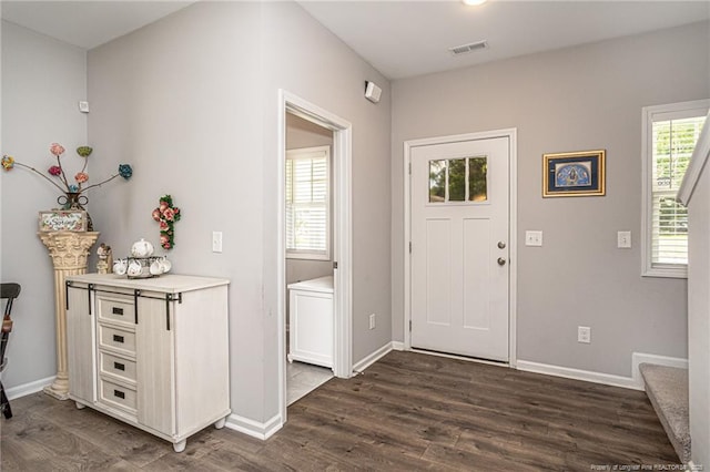 entryway with dark wood-type flooring, baseboards, and stairway