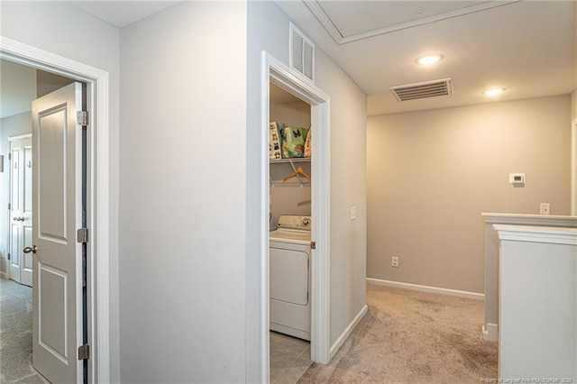 laundry area with washer / dryer, light carpet, attic access, and baseboards