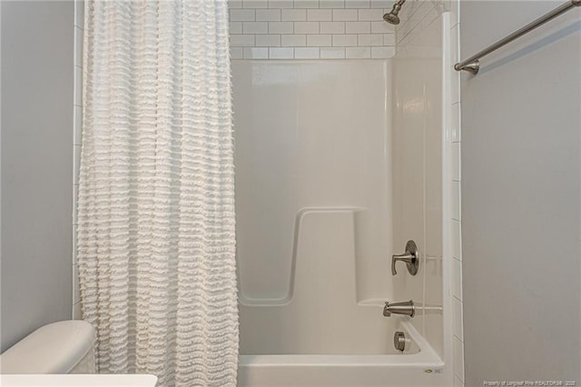 bathroom featuring toilet and shower / bath combination with curtain