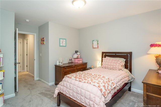 bedroom with light colored carpet and baseboards