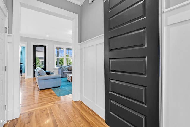 entryway featuring light wood finished floors, a decorative wall, and recessed lighting