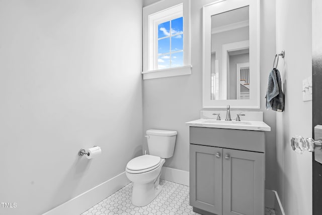 half bath featuring toilet, baseboards, vanity, and crown molding