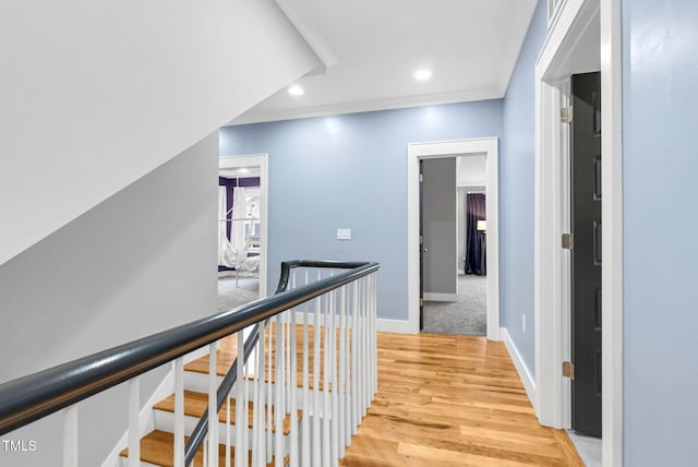 corridor featuring light wood finished floors, an upstairs landing, baseboards, and recessed lighting