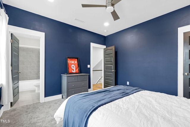 carpeted bedroom featuring baseboards, ensuite bathroom, and ceiling fan