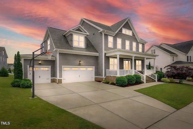 view of front facade with covered porch, driveway, a lawn, and a garage