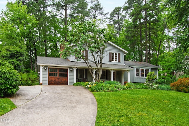 view of front of property featuring an attached garage, concrete driveway, a front yard, a porch, and board and batten siding