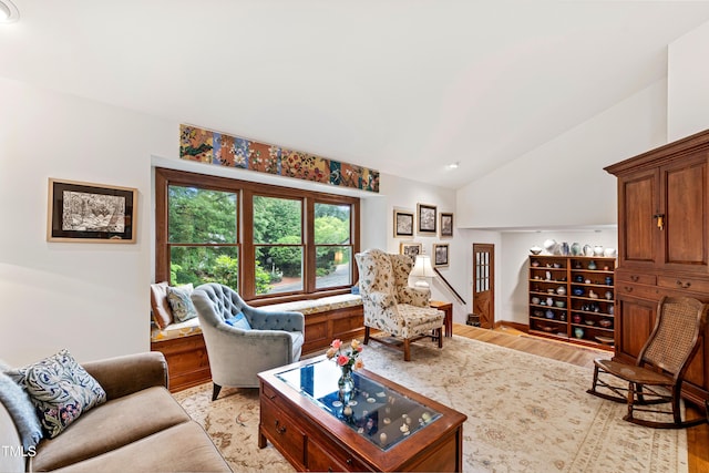 living area featuring lofted ceiling and light wood-style flooring