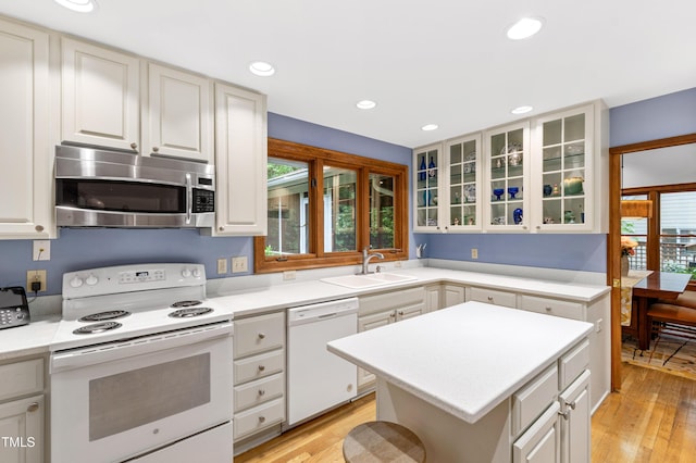 kitchen featuring white appliances, a sink, light wood-style floors, light countertops, and recessed lighting