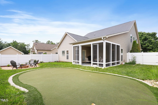 13 Nettletree Creek Ct, Youngsville, NC 27596 - rear view of house featuring a fire pit, a putting green, a sunroom, and roof with shingles