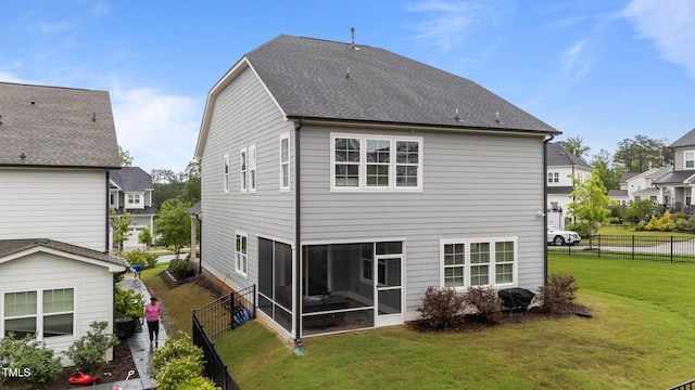 rear view of house featuring a sunroom, roof with shingles, and a residential view