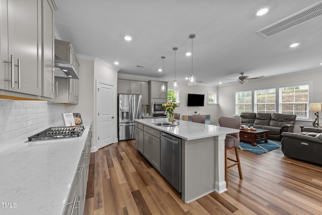 kitchen featuring stainless steel appliances, gray cabinetry, a sink, open floor plan, and recessed lighting