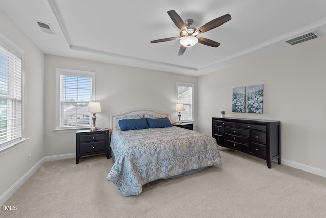 bedroom featuring a raised ceiling, carpet flooring, multiple windows, and baseboards