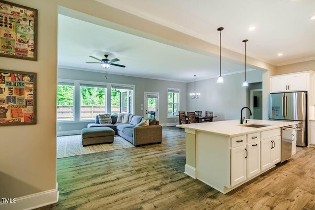 152 Chauncey Cir, Chapel Hill, NC 27516 - kitchen featuring a sink, ornamental molding, appliances with stainless steel finishes, light wood-style flooring, and white cabinets
