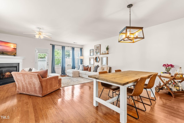 2635 Asher View Ct, Raleigh, NC 27606 - dining area with a glass covered fireplace, wood finished floors, and a ceiling fan