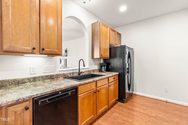 2635 Asher View Ct, Raleigh, NC 27606 - kitchen featuring dishwasher, a sink, light wood-type flooring, black fridge with ice dispenser, and brown cabinets