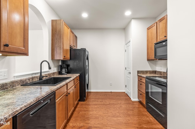 2635 Asher View Ct, Raleigh, NC 27606 - kitchen featuring black appliances, a sink, light wood-style floors, recessed lighting, and baseboards