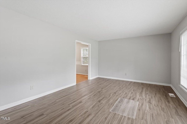 4812 Kaplan Dr, Raleigh, NC 27606 - spare room featuring wood finished floors, baseboards, and a textured ceiling