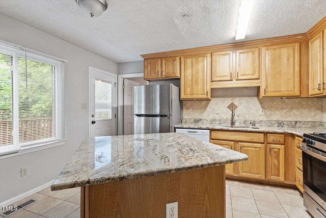 4812 Kaplan Dr, Raleigh, NC 27606 - kitchen with stainless steel appliances, a sink, light tile patterned floors, healthy amount of natural light, and a textured ceiling