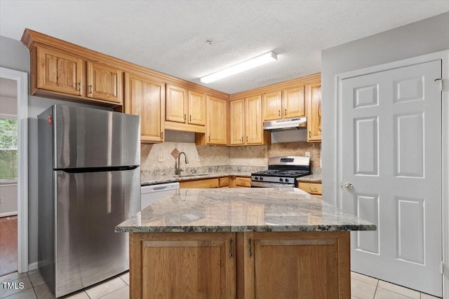 4812 Kaplan Dr, Raleigh, NC 27606 - kitchen featuring stainless steel appliances, under cabinet range hood, light tile patterned floors, light stone countertops, and backsplash