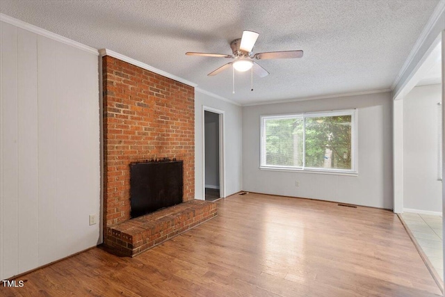 4812 Kaplan Dr, Raleigh, NC 27606 - unfurnished living room featuring light wood-style floors, a textured ceiling, a brick fireplace, a ceiling fan, and ornamental molding