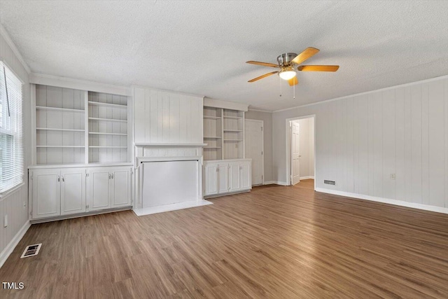 4812 Kaplan Dr, Raleigh, NC 27606 - unfurnished living room featuring a ceiling fan, a textured ceiling, wood finished floors, crown molding, and baseboards