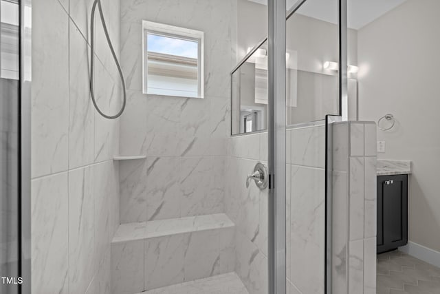 full bath with a marble finish shower and vanity