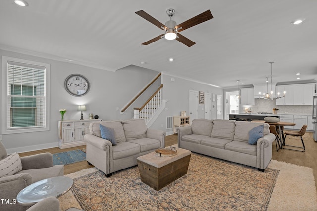 living room featuring light wood-type flooring, a chandelier, recessed lighting, stairs, and plenty of natural light
