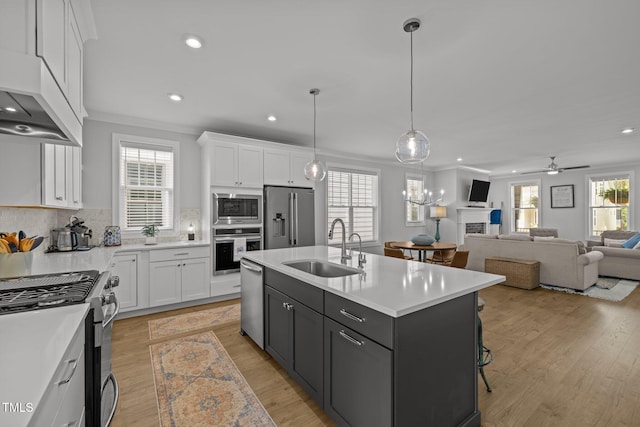 kitchen featuring appliances with stainless steel finishes, a sink, white cabinets, recessed lighting, and light countertops