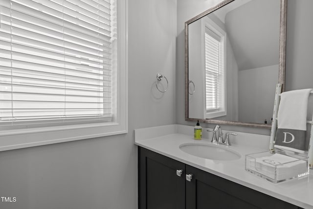 bathroom with vanity and lofted ceiling