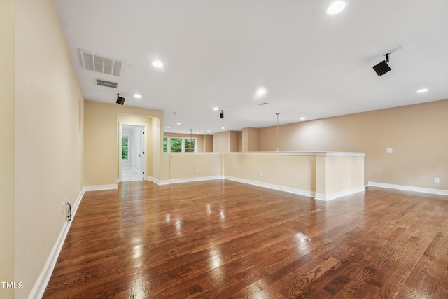 empty room with wood finished floors, recessed lighting, and baseboards