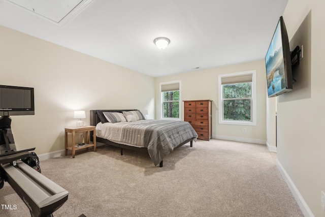 carpeted bedroom featuring baseboards and attic access
