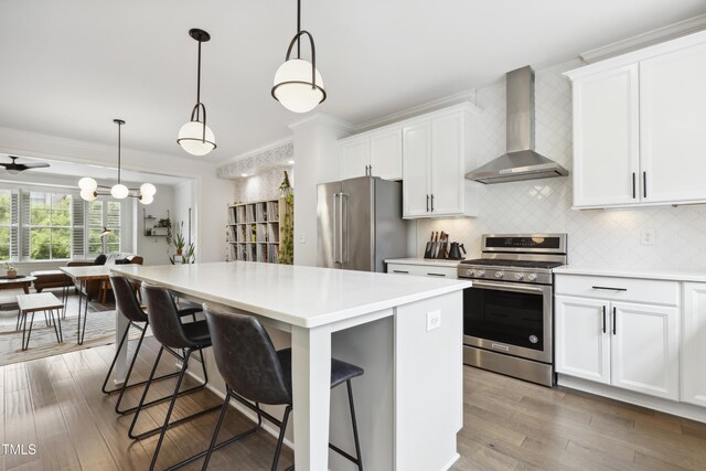 1602 Bowery Dr, Raleigh, NC 27607 - kitchen with stainless steel appliances, wall chimney range hood, a kitchen island, light countertops, and decorative backsplash