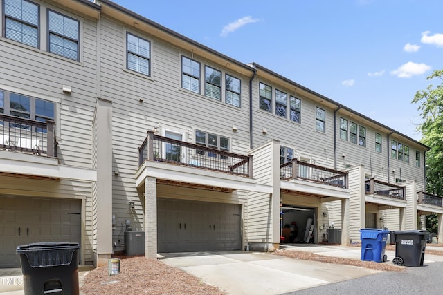1602 Bowery Dr, Raleigh, NC 27607 - back of house with central AC unit, a garage, and concrete driveway