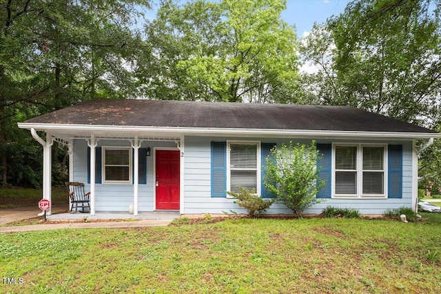 ranch-style home featuring covered porch and a front yard