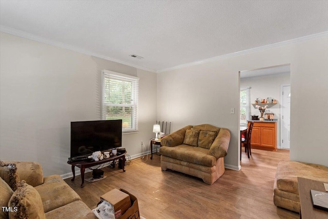 living room with ornamental molding, light wood finished floors, and baseboards