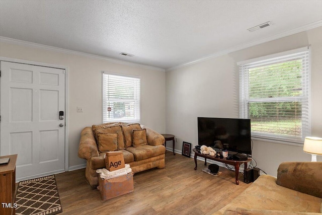 living room featuring light wood-type flooring, crown molding, and baseboards