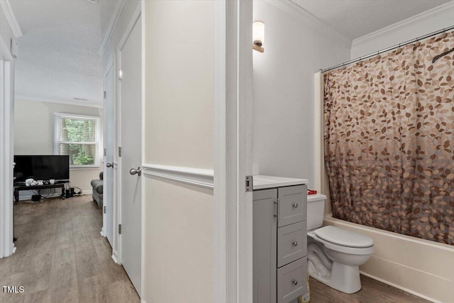bathroom featuring a textured ceiling, wood finished floors, toilet, ornamental molding, and shower / bath combo with shower curtain