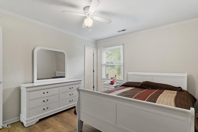 bedroom featuring wood finished floors, crown molding, a textured ceiling, and ceiling fan