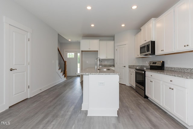 1739 Old Fields Blvd, Haw River, NC 27258 - kitchen featuring appliances with stainless steel finishes, a sink, light wood-style flooring, white cabinets, and recessed lighting