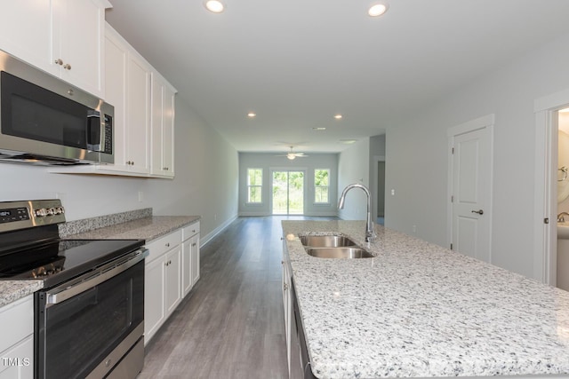 1739 Old Fields Blvd, Haw River, NC 27258 - kitchen with stainless steel appliances, a sink, wood finished floors, recessed lighting, and white cabinets