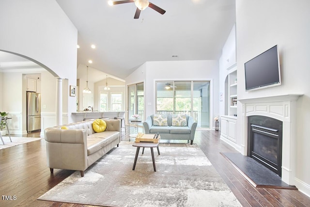 2916 Reynolda Cir, Durham, NC 27712 - living area with a ceiling fan, built in shelves, hardwood / wood-style floors, a glass covered fireplace, and high vaulted ceiling