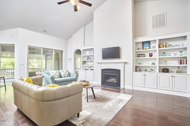 2916 Reynolda Cir, Durham, NC 27712 - living room featuring high vaulted ceiling, a ceiling fan, wood finished floors, a glass covered fireplace, and built in shelves