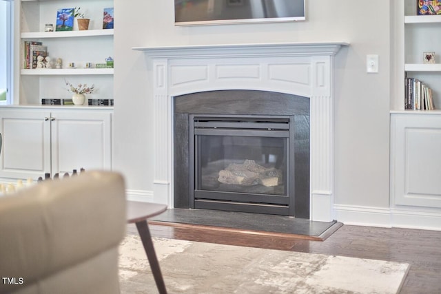 2916 Reynolda Cir, Durham, NC 27712 - detailed view of wood finished floors, built in shelves, a glass covered fireplace, and baseboards