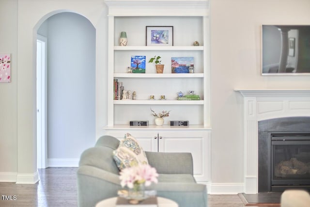 2916 Reynolda Cir, Durham, NC 27712 - living area featuring wood finished floors, arched walkways, built in shelves, and baseboards