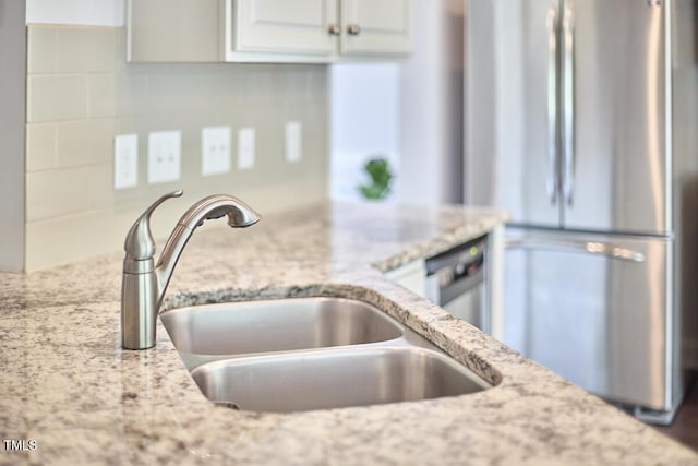 2916 Reynolda Cir, Durham, NC 27712 - kitchen with appliances with stainless steel finishes, a sink, light stone counters, and white cabinetry