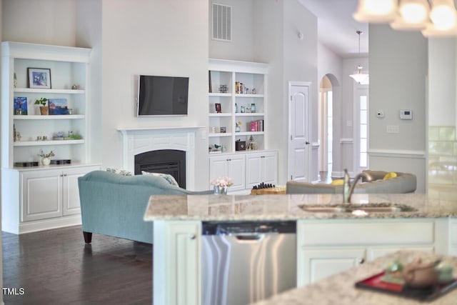 2916 Reynolda Cir, Durham, NC 27712 - kitchen featuring dishwasher, a sink, arched walkways, dark wood-style floors, and a fireplace